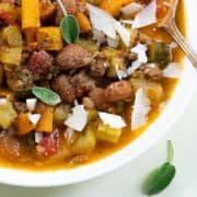 Overhead shot of beef minestrone soup with a spoon in the bowl off to the side.