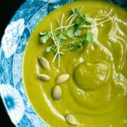 A bowl of broccoli sweet potato soup with garnishes.