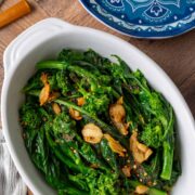 A plate of rapini with toasted garlic, red pepper flakes, salt and pepper.
