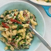 A bowl of pasta with chicken made with Boursin cheese, spinach and sun-dried tomatoes.