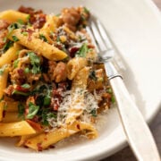 A bowl of creamy pasta with Italian sausage.