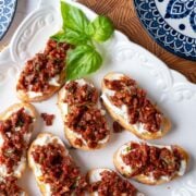 Sun-dried tomato bruschetta on a serving plate.