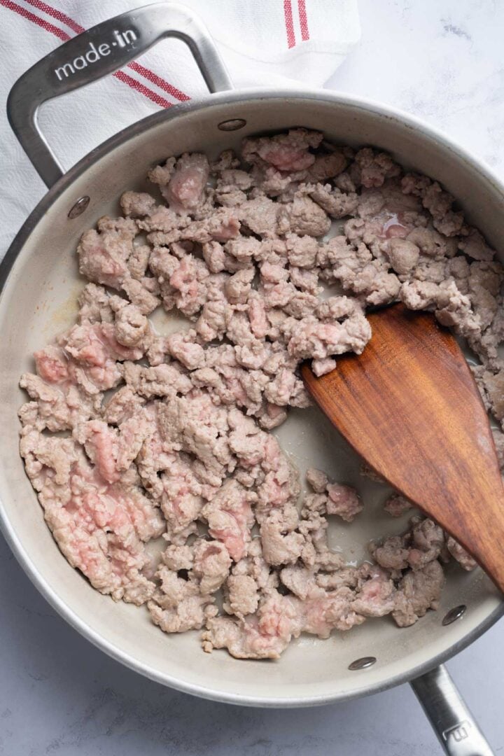 Cooking the ground turkey in a skillet.