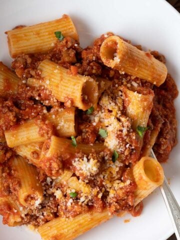 A plate of rigatoni with meat sauce.