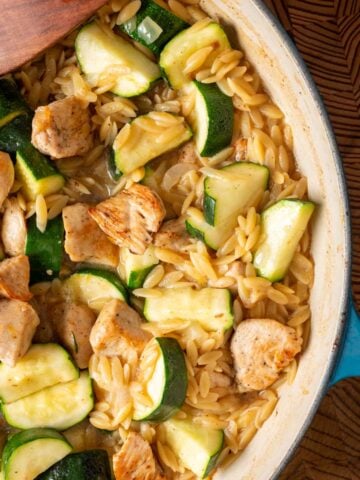 A skillet (one pan) with lemon chicken orzo pasta.