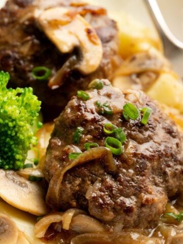 Hamburger steaks with onion and mushroom gravy in a plate.