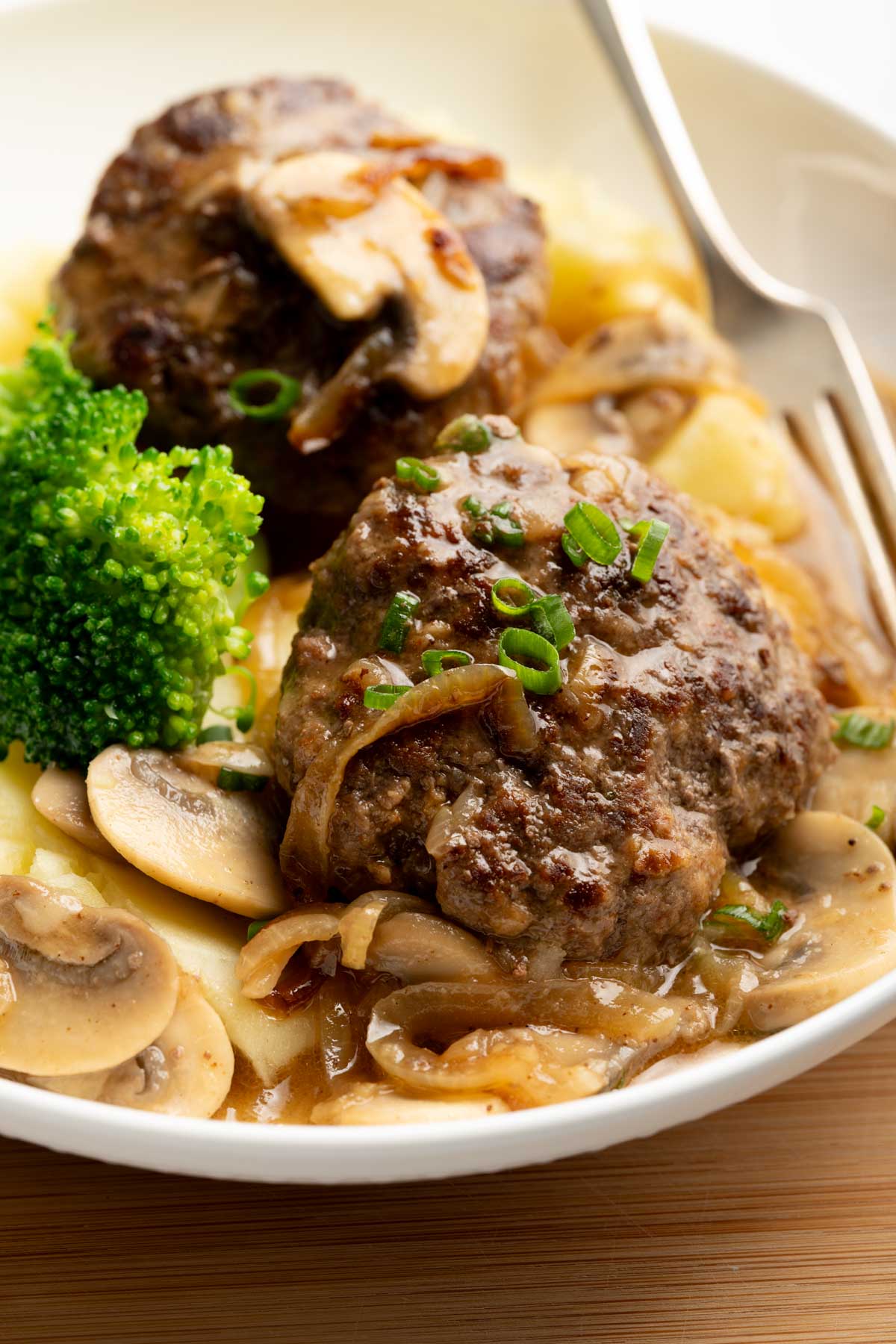 Hamburger steaks with onion and mushroom gravy in a plate.