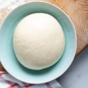 Same-day pizza dough ball in a shallow bowl.