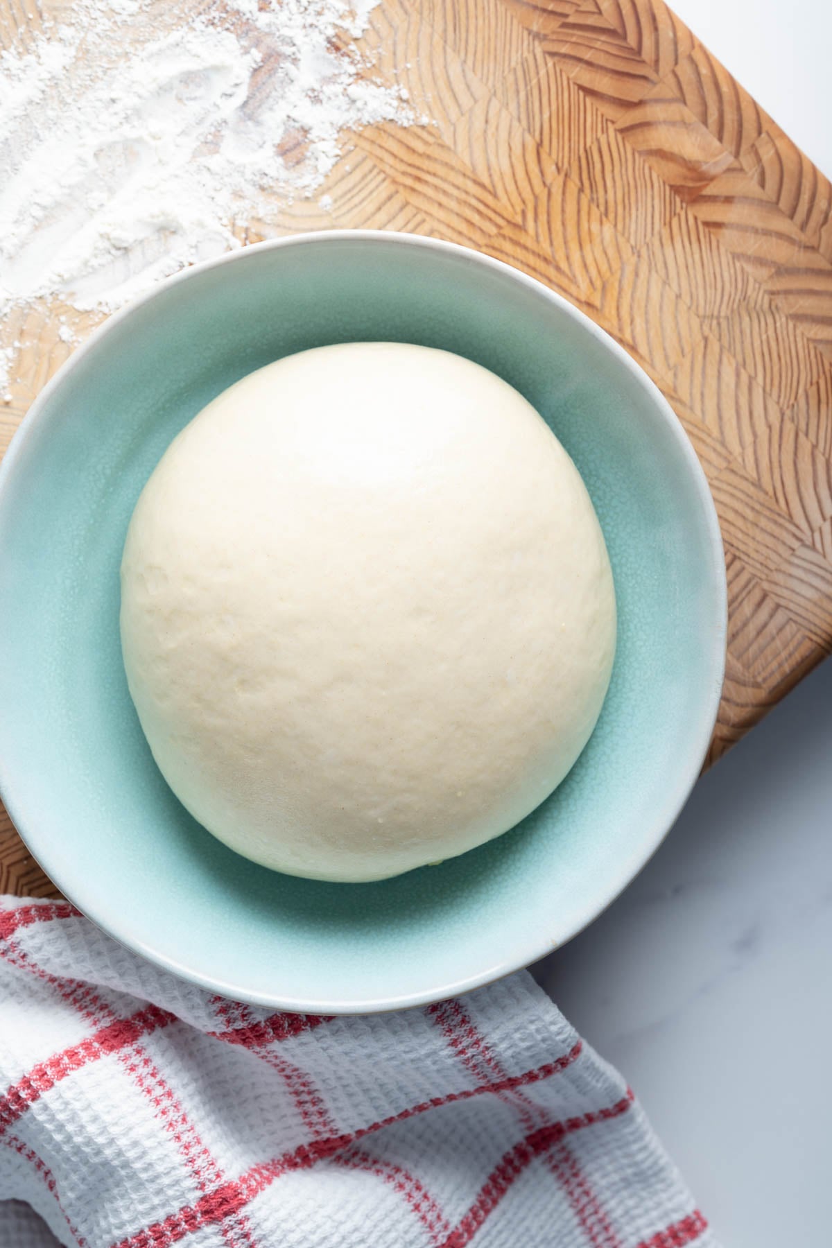 Same-day pizza dough ball in a shallow bowl.
