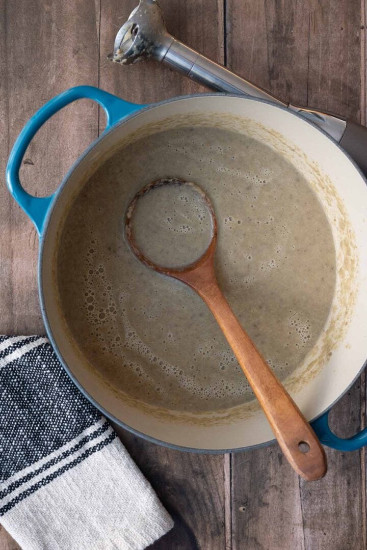 A Dutch oven with mushroom and leek soup that has been blended.