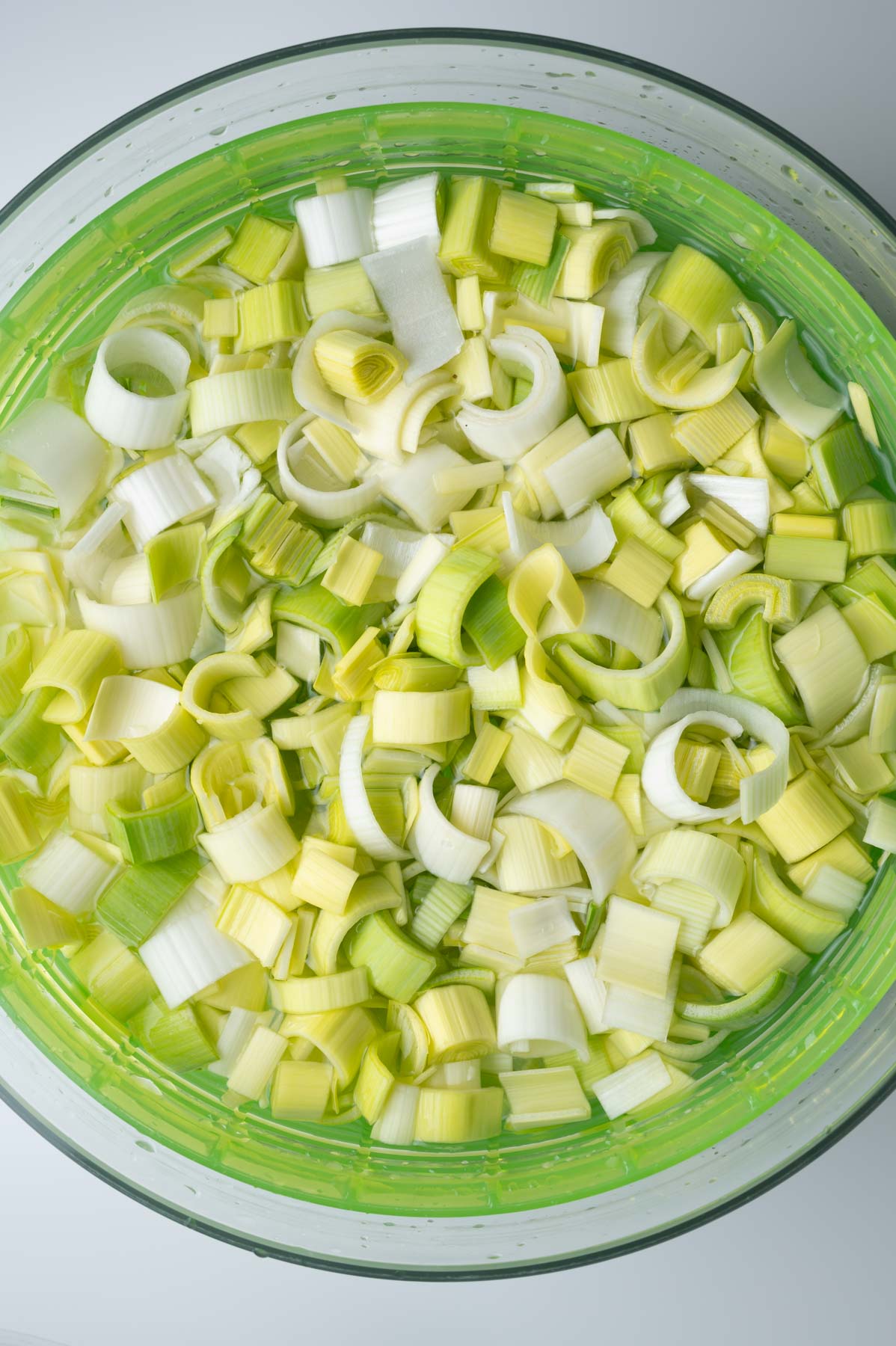 Chopped leeks in a large bowl of water.