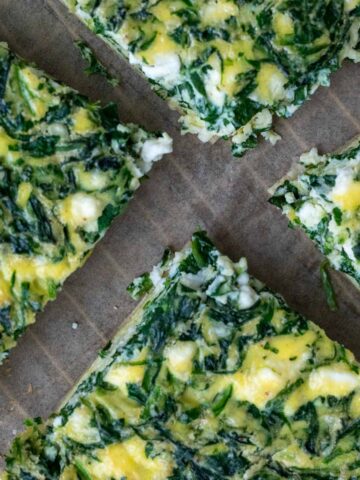 Four slices of tortilla quiche bake with spinach and feta.