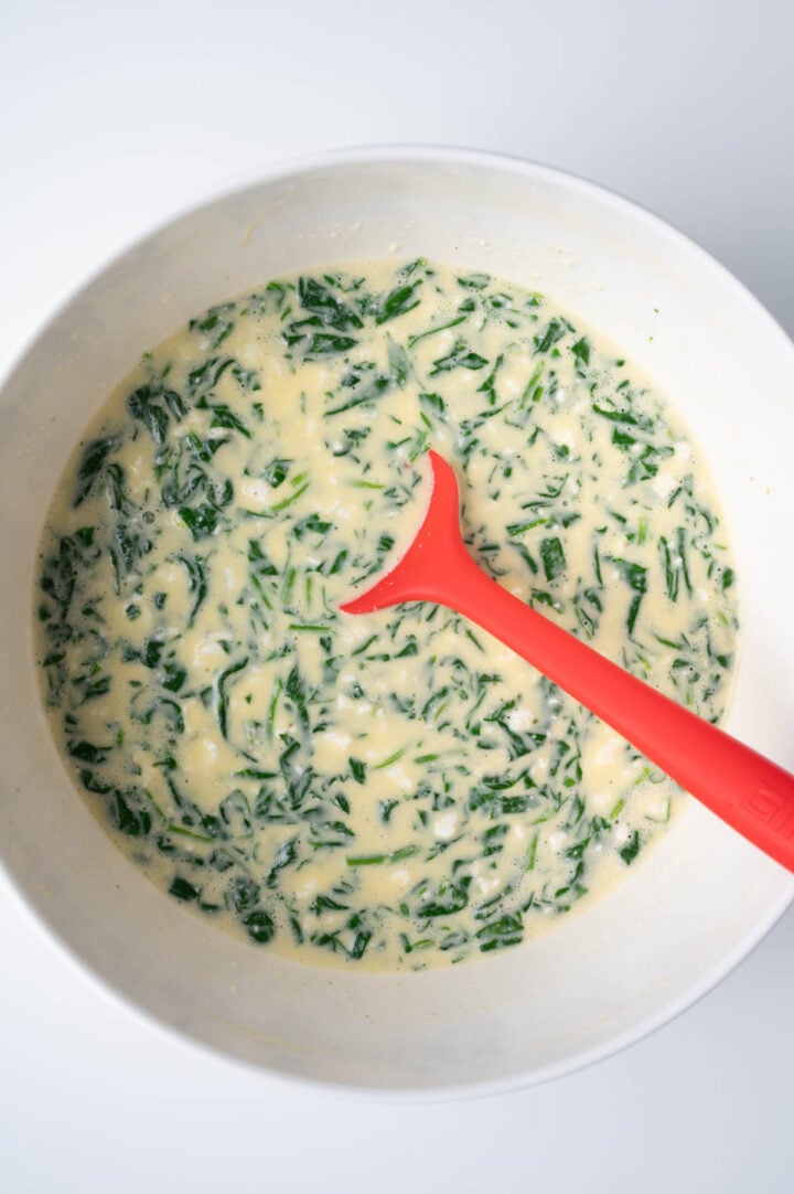 Mixing the quiche filling in a bowl.