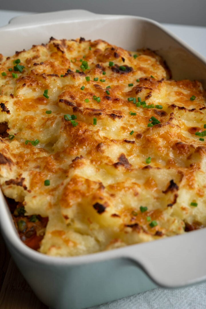A casserole dish with baked shepherd's pie with ground pork.