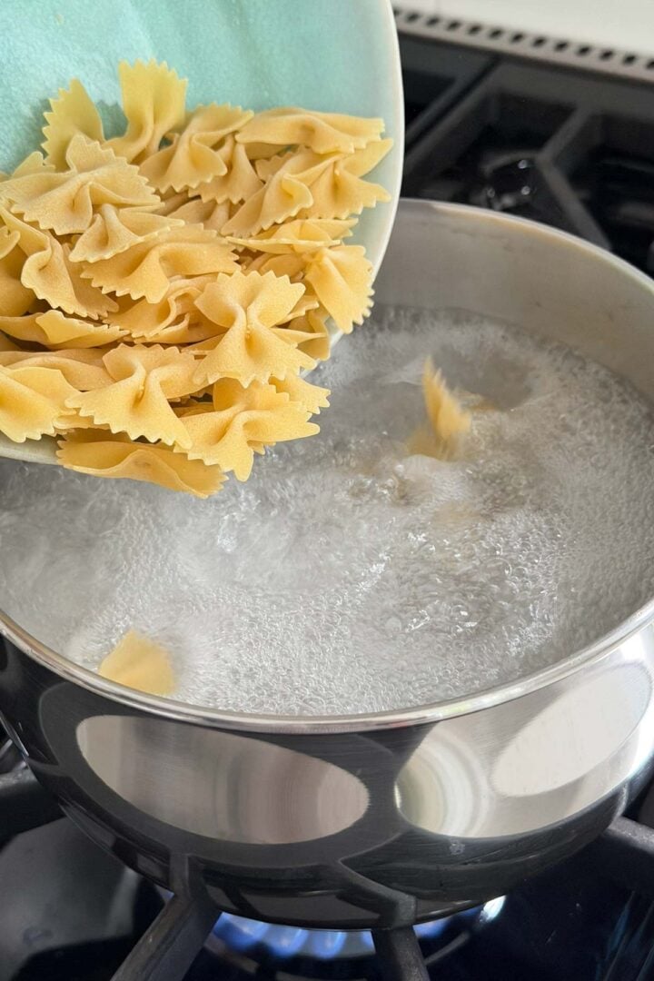 Adding farfalle to boiling water.